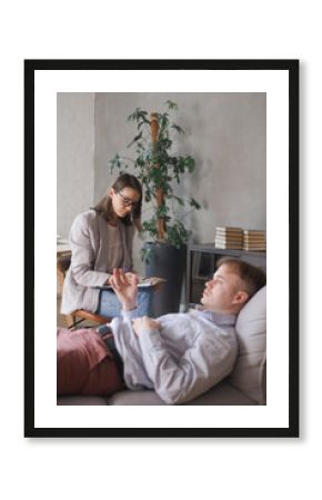 female psychologist conducts psychotherapy session for man. patient in clinic's office on couch talks about his worries and stresses. diagnosis of depression, anxiety disorder. taking care of mental