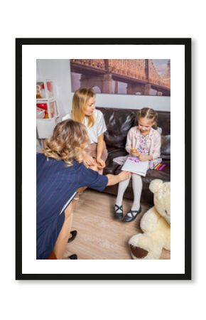 A girl psychologist communicates with the child at a family reception