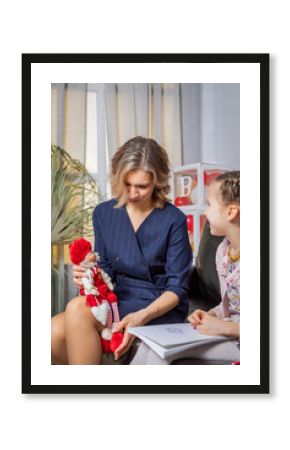 The girl psychologist plays a puppet character game with the child