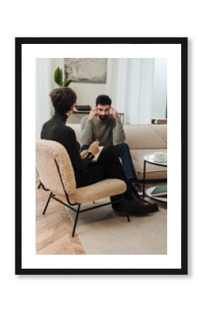 Man talking to psychologist about his problems while sitting on couch