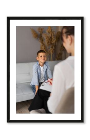 Preschooler boy visiting psychotherapist, woman and child talking about problem, psychotherapy session in office, kid smiling at psychologist