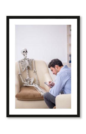 Young male psychologist meeting with skeleton