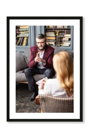 Businessman wearing dark red jacket sharing his worries with therapist