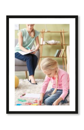 Female psychologist working with little girl in office