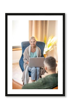 Psychoanalyst holding laptop while listening to patient