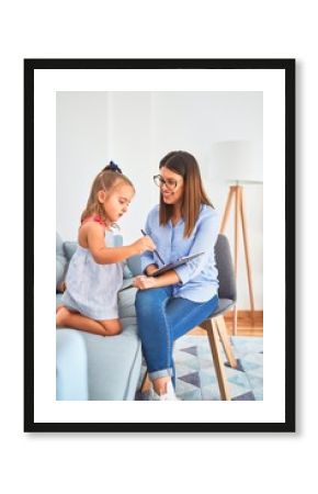 Young therapist woman speaking and treating child, counselor and behaviour correction at pedagogue payroom taking notes on clipboard