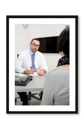 handsome male doctor with a female patient in hospital consultation office desk