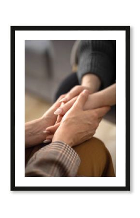 Two woman holding hands to each other concept of support care trust help sisterhood top view closeup