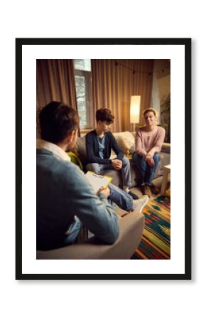 Man, psychologist discusses strategies with a teenage boy and his mother during a therapy session, emphasizing emotional support and understanding. Concept of psychology, assistance, therapy