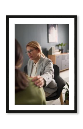 Vertical portrait of female therapist comforting young girl in emotional support group session