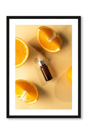 Vertical image of bottle with pipette and oranges with copy space on yellow background