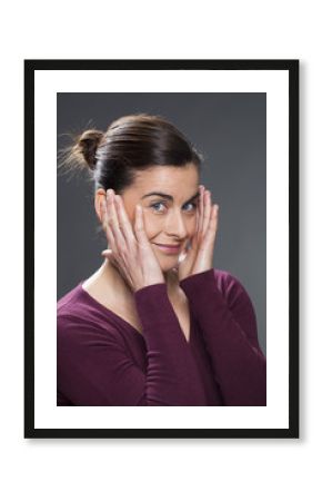 cheerful 30's woman smiling in practising face acupressure with hands on face and temples for natural eye care and facial contour exercise