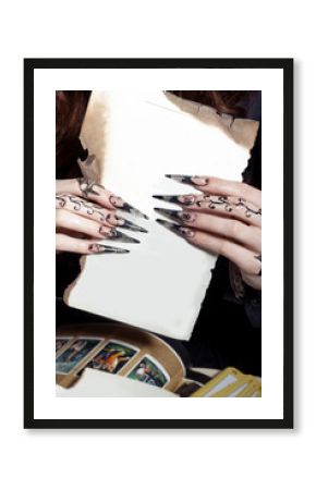 beautiful hands with long acrylic witch black nails holding a white sheet in the hands of