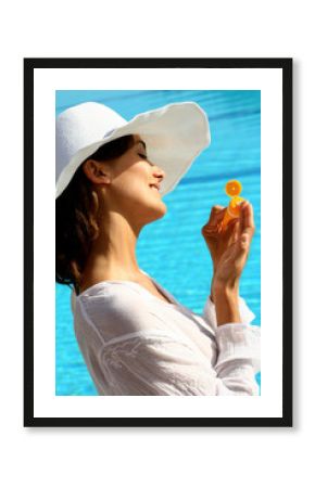 femme à la piscine appliquant une crème solaire