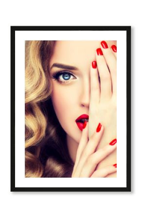 Beautiful  blonde model  girl  with long curly  hair . Hairstyle wavy curls . Red  lips and  nails manicure .   