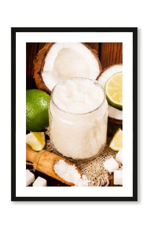 Homemade sugar scrub with lime and coconut on wooden background