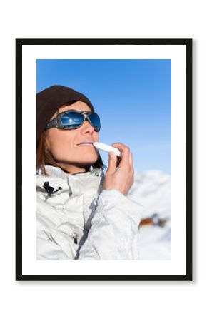 portrait de femme avec un stick écran total à lèvres à la neige