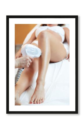 woman at cosmetics salon, legs laser epilation