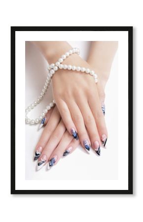 Beautiful female hands with blue and white manicure on a white background