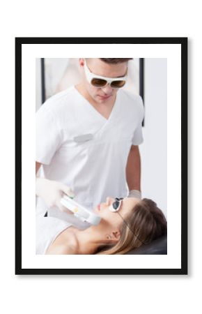 woman during face laser therapy in cosmetics