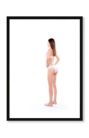 Full-size full-length half-turned back vertical portrait of stunning beautiful brunette thin skinny ideal woman's stature dressed in white classic underpants and brassiere isolated on background