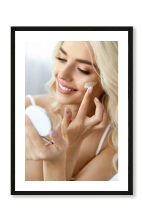 Beauty Face Care. Woman Applying Cream On Skin.