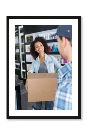 smiling hairdresser receiving parcel from deliveryman