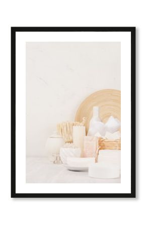 Organic homemade white cosmetics and beige wooden bamboo bath accessories on white wooden background, border.