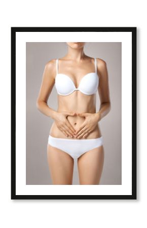 Health issues - female suffering from pain and holding her hands on the stomach