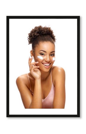 Аttractive girl applying moisturizing cream. Photo of smiling african american girl with healthy skin on white background. Skin care and beauty concept