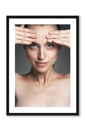 Portrait of a young woman with wrinkles on his forehead on white background