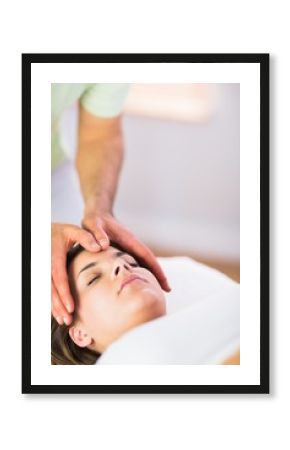 Relaxed pregnant woman getting reiki treatment