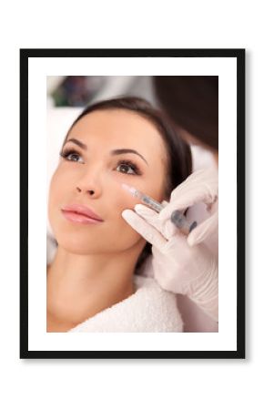 Professional young cosmetician is serving her patient