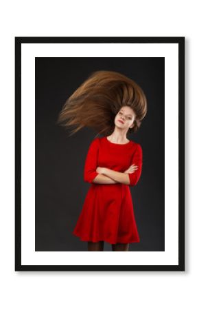 Portrait of a smiling young beautiful girl in a red dress with a