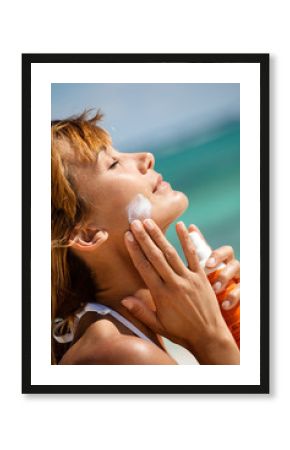 femme s'appliquant une crème solaire