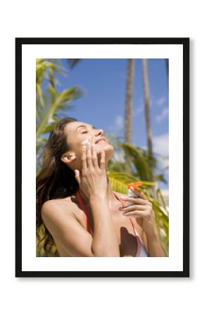 femme s'appliquant de la crème solaire 