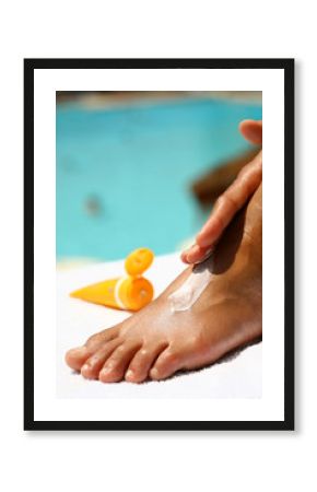  application d'une crème solaire sur les pieds à la piscine