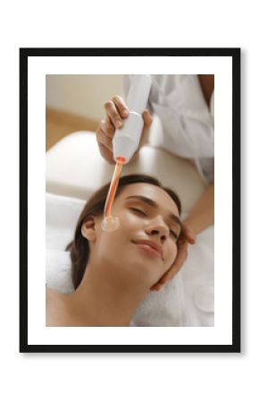 Face Beauty Treatment. Woman Using Darsonval Skin Care Device