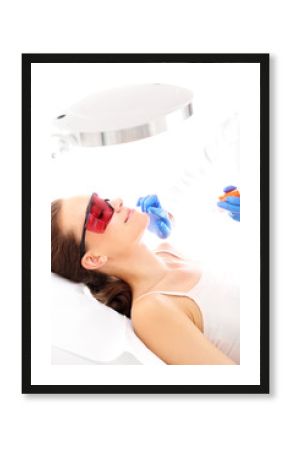 Dermatologia,  fotoodmładzanie. Klinika kosmetyczna, kobieta podczas zabiegu depilacji laserowej twarzy