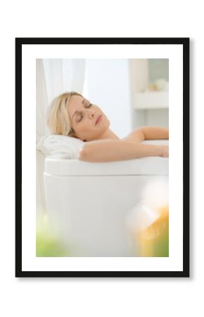 Beautiful blond woman relaxing in bathtub