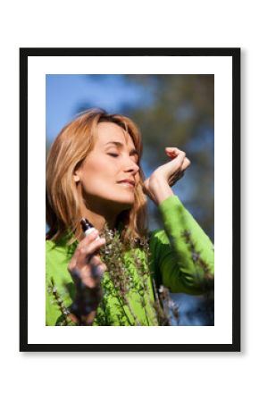 femme dans la nature respirant de l'huile essentielle de romarin