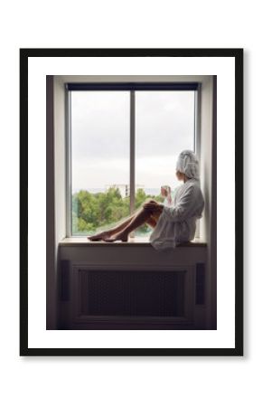 girl in a bathrobe and towel on head sitting