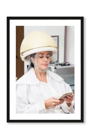 Woman under a professional hair steamer with a hair treatment