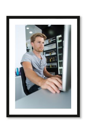 happy young man using pc at hair salon