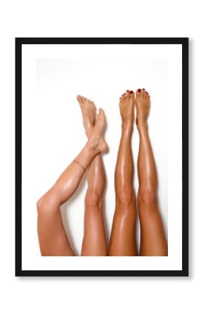 two beautiful pairs of smooth woman's legs after laser hair removal on the white background