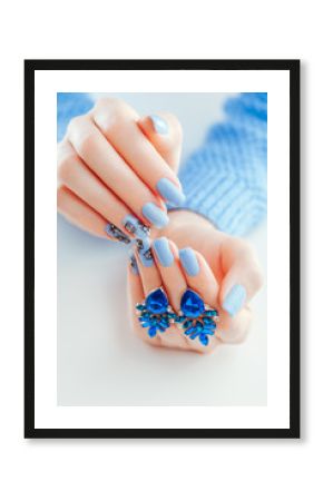 Beautiful Christmas manicure with earrings. Blue nails with black design and rhinestones.