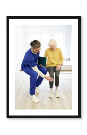 Physiotherapist examining patient's knee. Senior patient with knee injury visit her physiotherapist