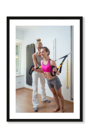 Woman using sling trainer during physical therapy