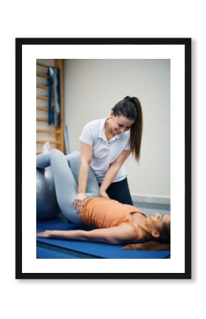 Happy female physiotherapist works with young woman health club.