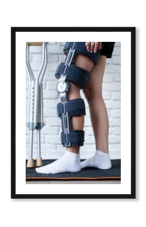 Female wearing knee orthosis or knee support brace after surgery on leg